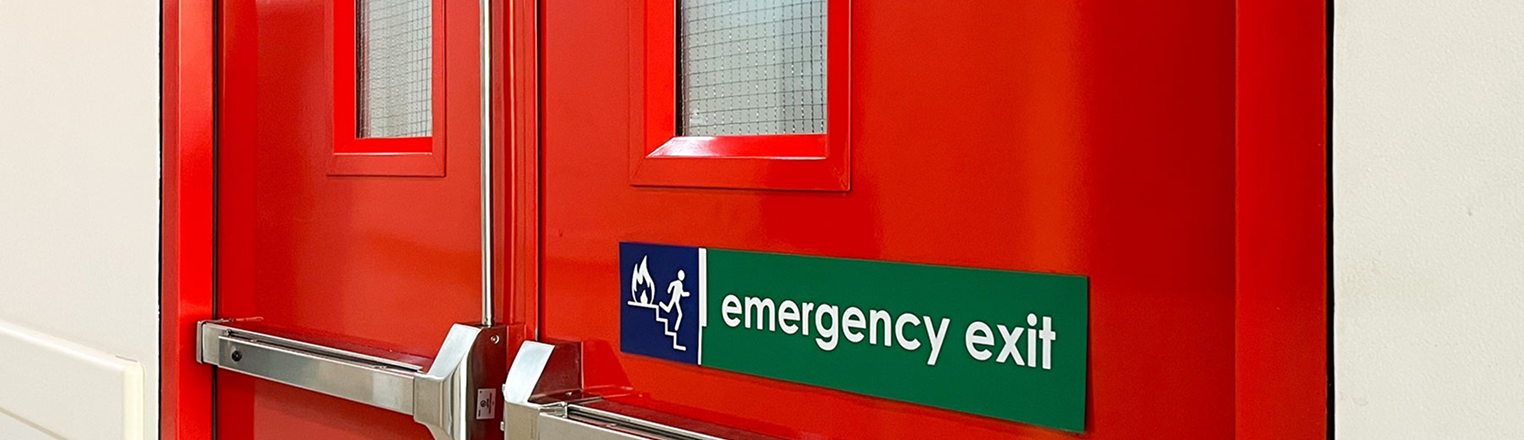 Red emergency exit door with a fire escape sign on the door